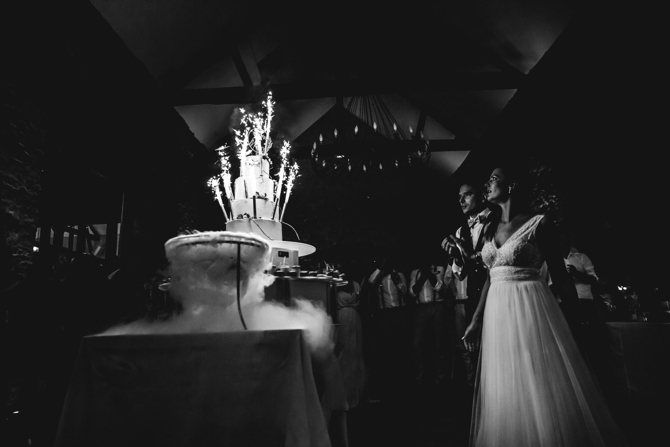 mariés en soirée devant gâteau avec bougies photographie noir et blanc